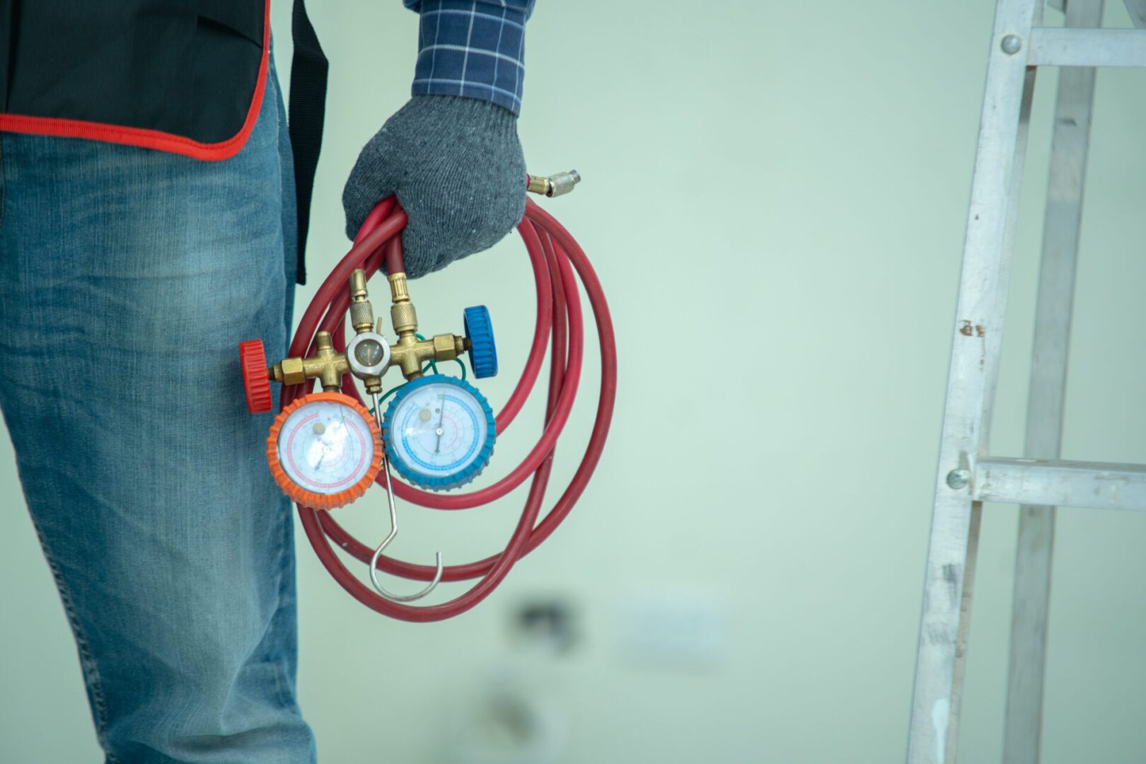 The technician is checking the air system,measuring equipment fo A person holding two gauges and a hose.